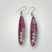 Pair of earrings with pink and silver design on a white background